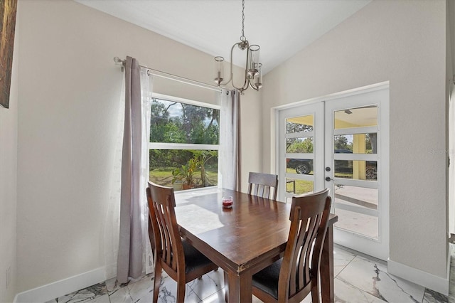 dining space featuring lofted ceiling, french doors, a wealth of natural light, and a chandelier