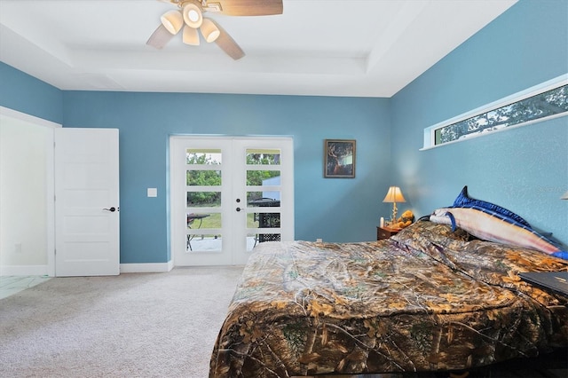 carpeted bedroom featuring ceiling fan, french doors, and a raised ceiling