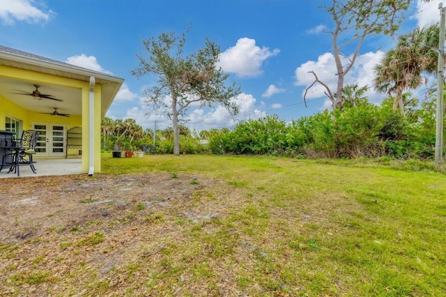 view of yard with ceiling fan and a patio