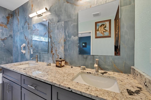 11247 Euler Ave, Englewood, FL 34224 - bathroom featuring tile walls, double vanity, and backsplash