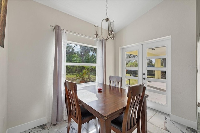 11247 Euler Ave, Englewood, FL 34224 - dining space with french doors, baseboards, a chandelier, light marble finish floors, and lofted ceiling