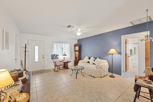 living room featuring ceiling fan, light tile patterned floors, and a textured ceiling