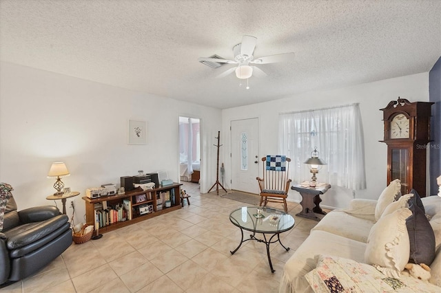 living room featuring ceiling fan and a textured ceiling