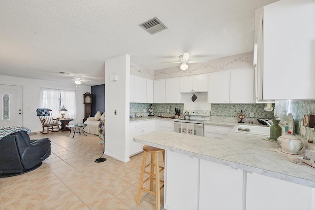 kitchen with sink, white electric range, a kitchen breakfast bar, kitchen peninsula, and white cabinets