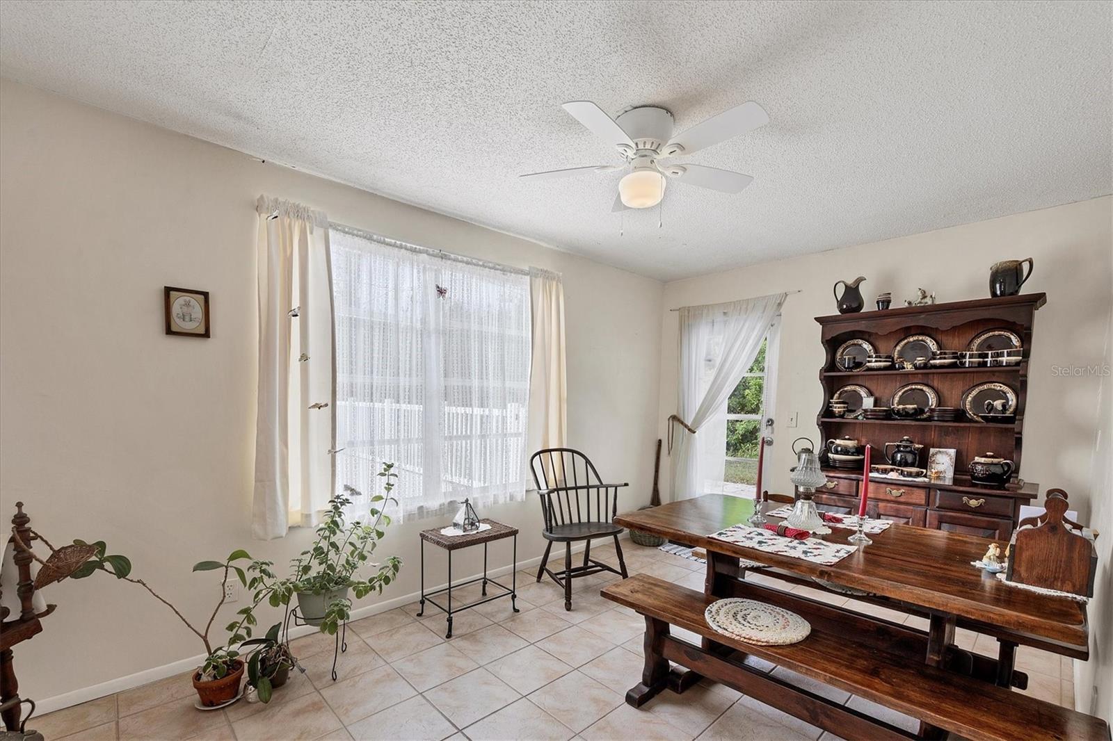 tiled home office with ceiling fan and a textured ceiling