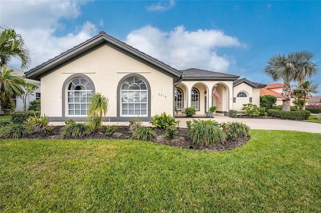 mediterranean / spanish house with a front lawn