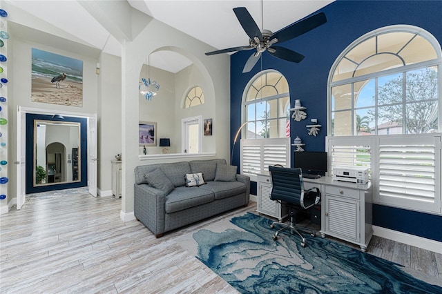 office area featuring light hardwood / wood-style floors, high vaulted ceiling, and ceiling fan