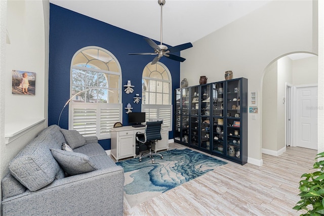 office with ceiling fan, light wood-type flooring, and high vaulted ceiling