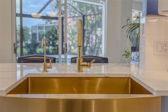 kitchen featuring light stone counters and sink