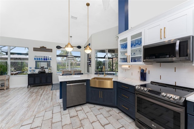 kitchen with white cabinetry, sink, backsplash, decorative light fixtures, and appliances with stainless steel finishes