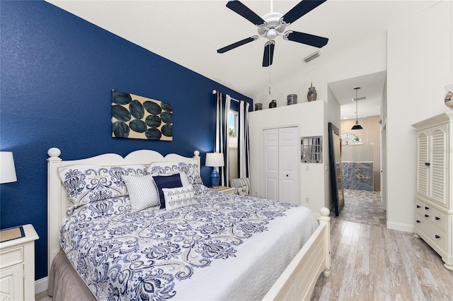 bedroom with ceiling fan, lofted ceiling, light hardwood / wood-style flooring, and a closet