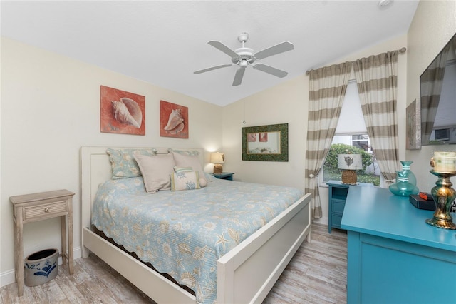 bedroom featuring ceiling fan, light hardwood / wood-style floors, and vaulted ceiling