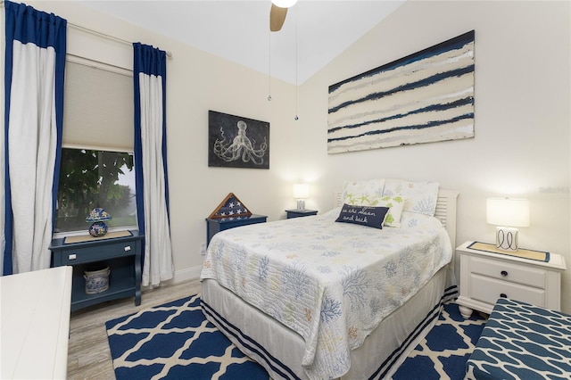 bedroom with ceiling fan, light wood-type flooring, and lofted ceiling