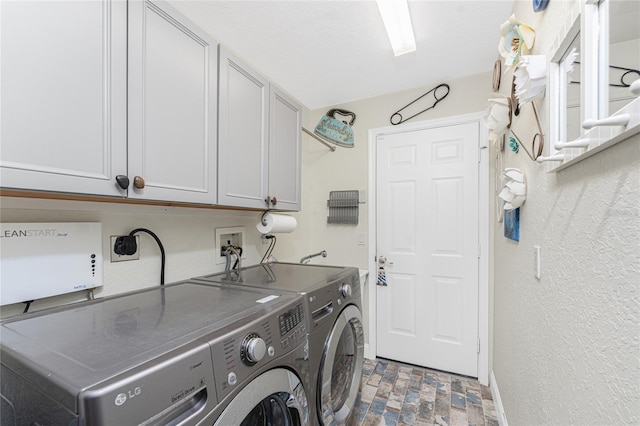 clothes washing area with cabinets and independent washer and dryer