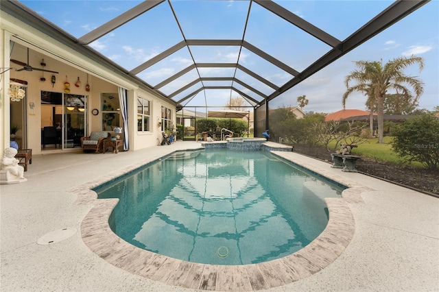 view of pool with an in ground hot tub, a patio, glass enclosure, and ceiling fan