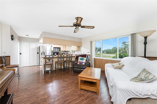 living room with ceiling fan and dark hardwood / wood-style floors