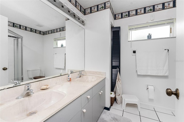 bathroom featuring vanity, tile patterned floors, a textured ceiling, and toilet