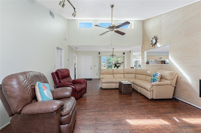 living room featuring a high ceiling, ceiling fan, and dark hardwood / wood-style flooring