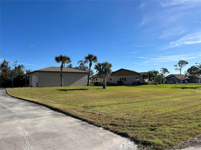 view of side of home with a garage, a lawn, and stucco siding