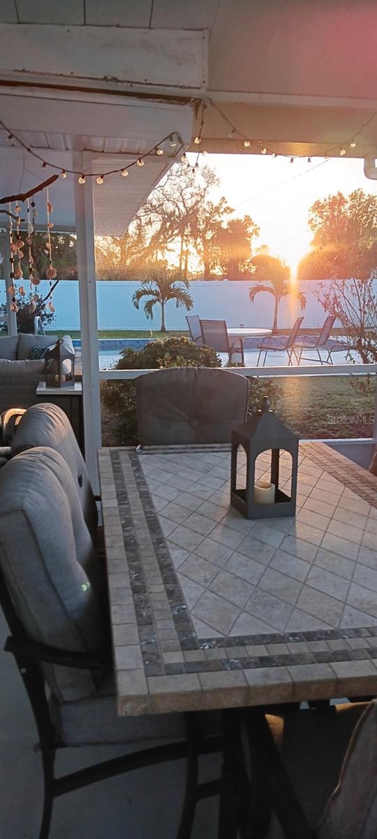 patio terrace at dusk featuring a water view and a pergola