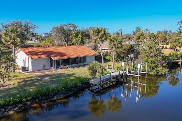 dock area featuring a water view, cooling unit, and a lawn