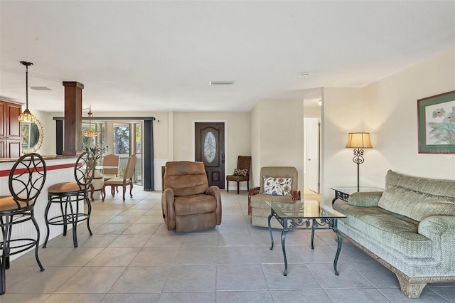 living room with light tile patterned floors and decorative columns