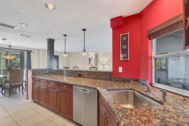 kitchen with dishwasher, sink, pendant lighting, dark stone counters, and light tile patterned flooring