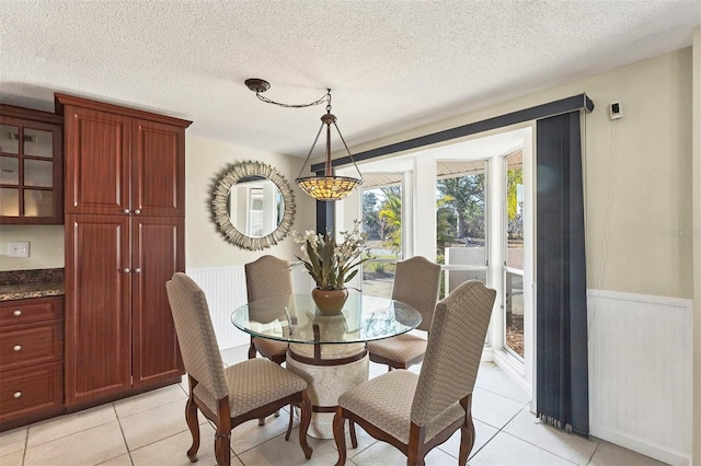 tiled dining space with a textured ceiling and wood walls