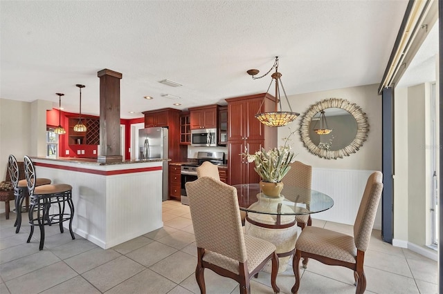 tiled dining area with a textured ceiling