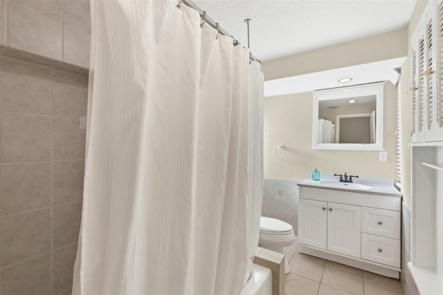 bathroom featuring a shower with shower curtain, tile patterned floors, a textured ceiling, vanity, and tile walls