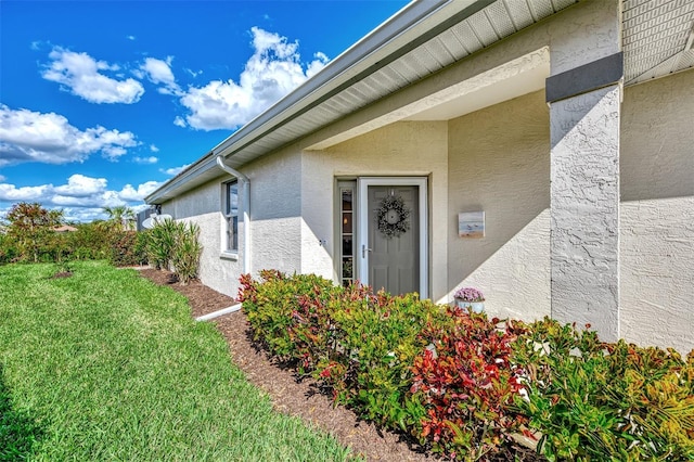 entrance to property featuring a lawn