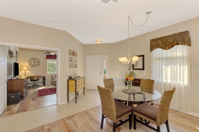 tiled dining area featuring ceiling fan with notable chandelier