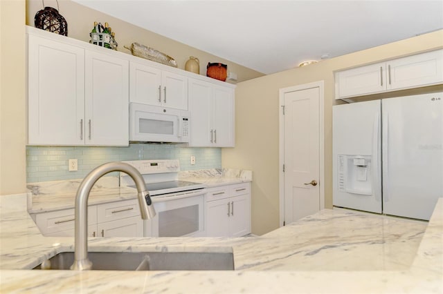 kitchen featuring white cabinetry, sink, light stone counters, backsplash, and white appliances