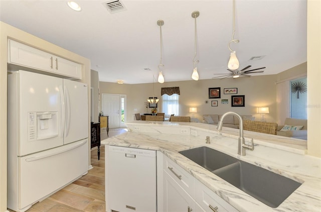 kitchen featuring sink, white cabinets, pendant lighting, and white appliances