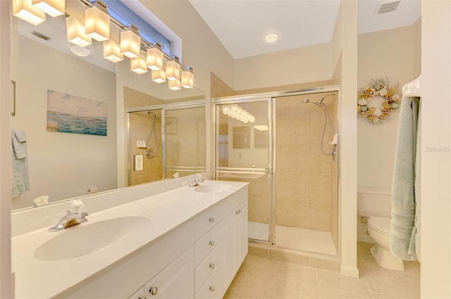 bathroom featuring toilet, vanity, tile patterned floors, and a shower with door