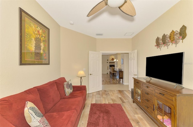 living room featuring ceiling fan and light wood-type flooring