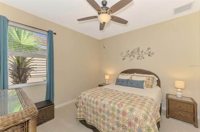 bedroom featuring multiple windows, light colored carpet, and ceiling fan