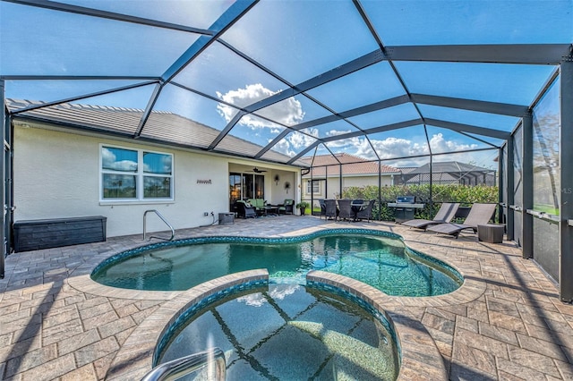 view of swimming pool with an in ground hot tub, ceiling fan, glass enclosure, grilling area, and a patio area