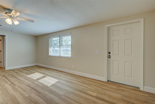 foyer featuring ceiling fan, light hardwood / wood-style flooring, and a textured ceiling