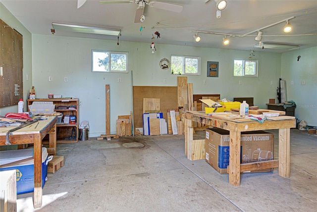 misc room with a workshop area, ceiling fan, a healthy amount of sunlight, and concrete flooring