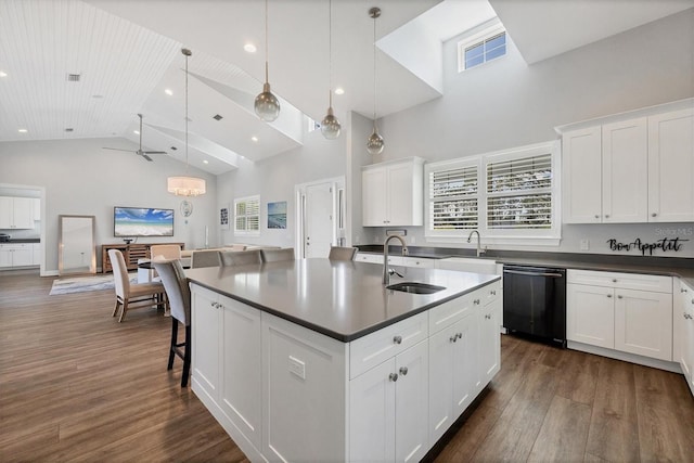 kitchen featuring ceiling fan, black dishwasher, a center island with sink, and sink