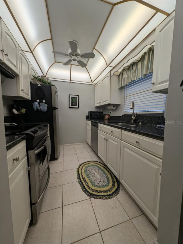 kitchen with sink, ceiling fan, appliances with stainless steel finishes, light tile patterned flooring, and white cabinetry