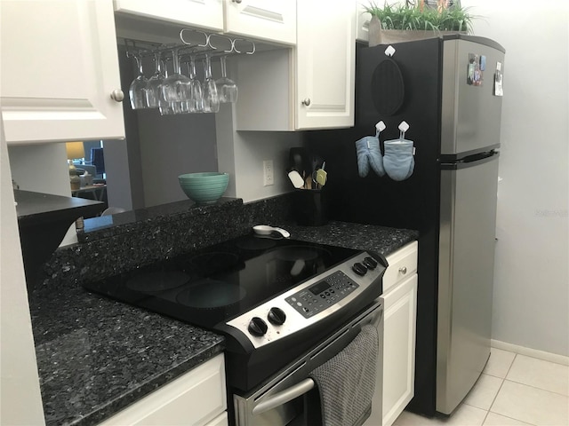 kitchen featuring white cabinetry, light tile patterned flooring, dark stone counters, and stainless steel range with electric stovetop