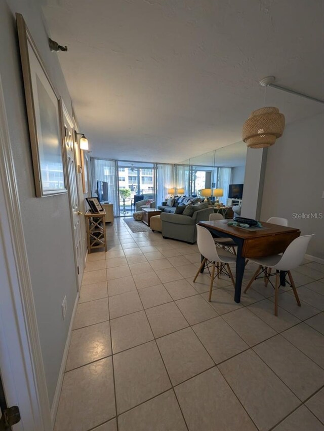 tiled dining space featuring a wall of windows