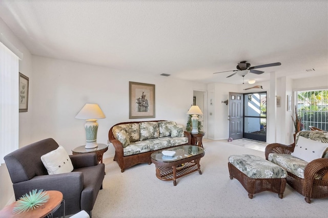 living room with ceiling fan and a textured ceiling