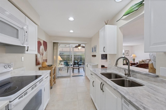 kitchen featuring light stone countertops, sink, white cabinets, and white appliances