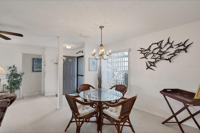 dining room featuring ceiling fan with notable chandelier and a textured ceiling