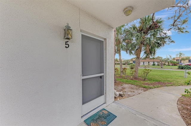 doorway to property with a yard