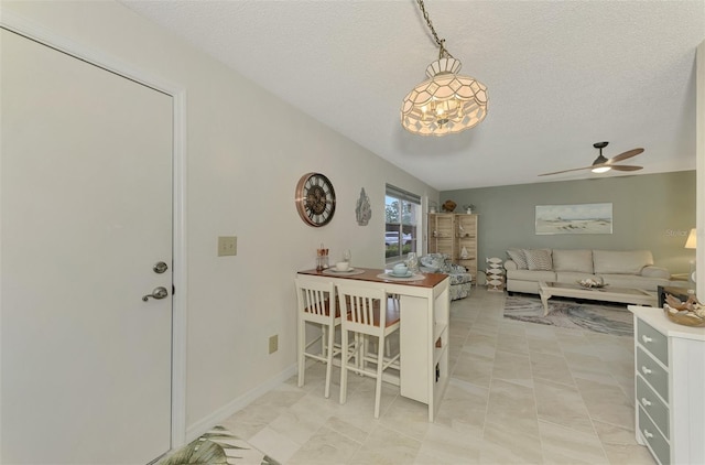 dining area with ceiling fan and a textured ceiling