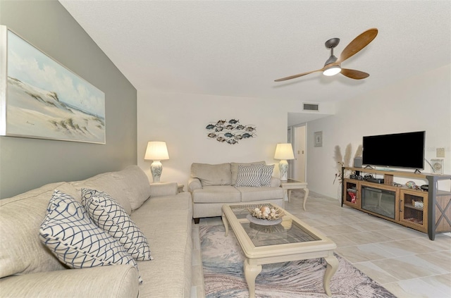 living room featuring ceiling fan and a textured ceiling